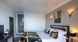 een slaapkamer met een bed met witte lakens en kussens bij Hôtel Capo Rosso in Piana