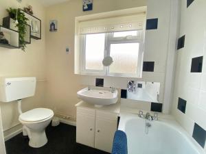 a bathroom with a toilet and a sink and a tub at Cosy and Comfortable Holiday Chalet 10 minutes walk to the beach, Norfolk in Great Yarmouth