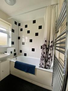 a white bathroom with a tub and a sink at Cosy and Comfortable Holiday Chalet 10 minutes walk to the beach, Norfolk in Great Yarmouth