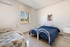 ein Schlafzimmer mit zwei Betten und einem Fenster in der Unterkunft Villa Spiaggia degli Angeli in Porto Cesareo