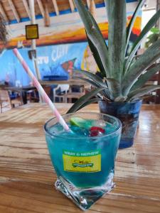 un vaso de agua sobre una mesa con una planta en Ltu Garden, en Negril