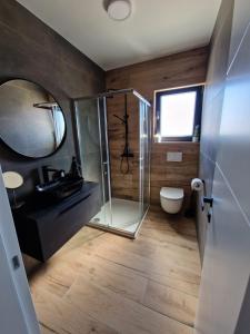 La salle de bains est pourvue d'une douche, d'un lavabo et de toilettes. dans l'établissement Apartment Luka, à Privlaka