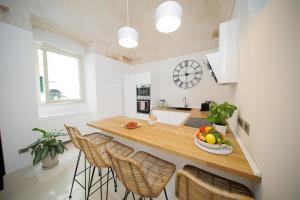 a kitchen with a counter with a bowl of fruit on it at Dimora Palestro by MANZONI COLLECTION in Monopoli