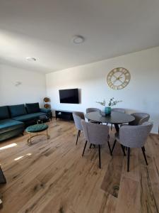 - un salon avec un canapé, une table et des chaises dans l'établissement Apartment Luka, à Privlaka