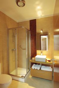 uma casa de banho com um chuveiro, um lavatório e um WC. em Sagres Time Apartamentos em Sagres