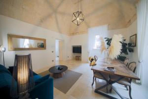 a living room with a table and a blue couch at Dimora Palestro by MANZONI COLLECTION in Monopoli