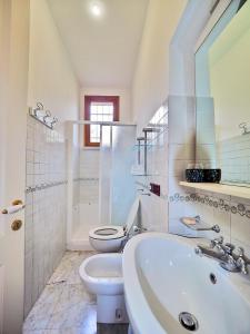ein weißes Bad mit einem WC und einem Waschbecken in der Unterkunft Tra gli Ulivi e il Mare in Tellaro