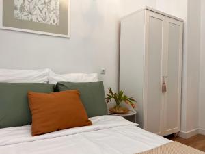 a bedroom with a bed with an orange pillow on it at Heart of Center in Rzeszów