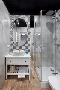 a bathroom with a sink and a shower and a mirror at Długa 18 Apartament Premium z antresolą in Poznań