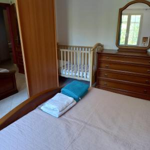 - une chambre avec un grand lit, une commode et un lit bébé dans l'établissement Affitto bilocale 4 posti letto Ardali-Ogliastra, à Ardali