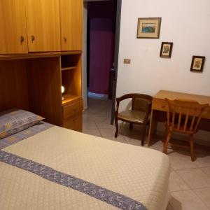 - une chambre avec un lit, une table et une chaise dans l'établissement Affitto bilocale 4 posti letto Ardali-Ogliastra, à Ardali