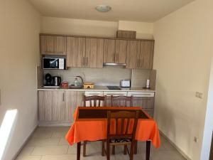 cocina con mesa con sillas y microondas en Azúr Ház Kamilla Apartman, en Sárvár