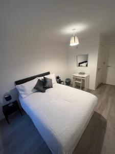 a white bed with two pillows on it in a bedroom at 2 bedroom light, spacious aptmnt nr Heathrow in Cranford