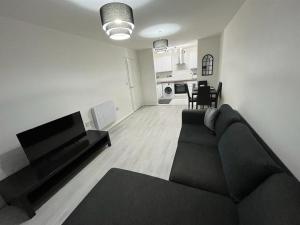 2 bedroom light, spacious aptmnt nr Heathrow في Cranford: غرفة معيشة مع أريكة ومطبخ