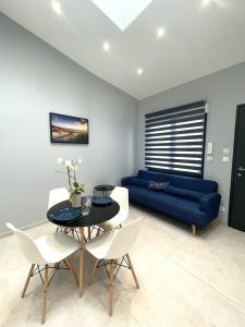 - un salon avec un canapé bleu, une table et des chaises dans l'établissement Montreuil Appart Holidays, à Montreuil-sur-Mer