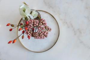 a bunch of grapes on a plate with a flower at Modern Apartments Near Harrods and the Science Museum in London