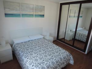 1 dormitorio con cama y espejo grande en Apartamento con vistas Mar de Salinas en Salinas