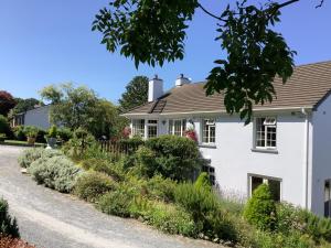 una casa blanca con un jardín delante de ella en O' Sullivan's B & B en Killarney