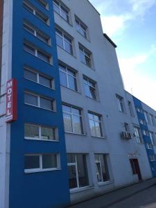 un edificio azul con un cartel delante en Motelis Jonučiai, en Garliava