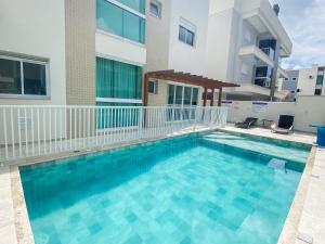 a swimming pool in front of a building at Apartamento encantador com piscina na Praia de Palmas Governador Celso Ramos in Governador Celso Ramos