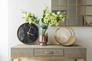 a table with a vase of flowers and a mirror at Modern Apartments Near Harrods and the Science Museum in London