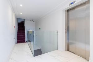 a hallway with a glass door in a building at Modern Apartments Near Harrods and the Science Museum in London