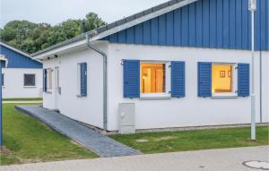 a white building with blue shuttered windows at Ferienhaus 32 Altefhr in Altefähr