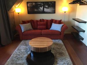 a living room with a red couch and a coffee table at Hotel Buenos in Geldrop