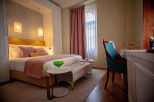une chambre d'hôtel avec un lit et un bol vert sur une table dans l'établissement Storytellers Palace, à São Martinho do Porto