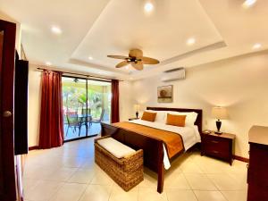 a bedroom with a bed and a ceiling fan at Monte Carlo Luxury Condominiums in Jacó +282 photos