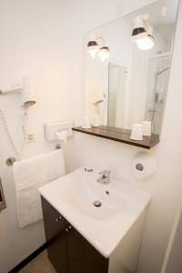 een witte badkamer met een wastafel en een spiegel bij So'Lodge Niort A83 in La Creche