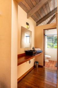 ein Badezimmer mit einem Waschbecken und einem Spiegel auf der Theke in der Unterkunft Vieques Villa Gallega - Oceanview w/Infinity Pool in Vieques