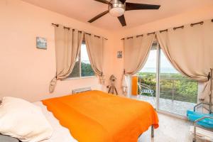 Vieques Villa Gallega - Oceanview w/Infinity Pool في بييكيس: غرفة نوم بسرير ونافذة كبيرة