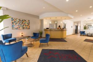 une salle d'attente avec des chaises bleues et un comptoir dans l'établissement Hotel du Nord, à Québec