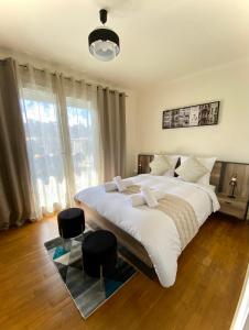 1 dormitorio con 1 cama grande y 2 taburetes en Maison face à la cité, en Carcassonne