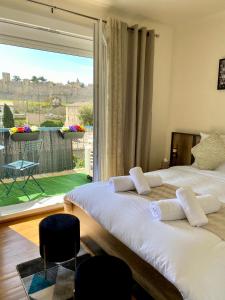 Duas camas num quarto com uma janela grande em Maison face à la cité em Carcassonne