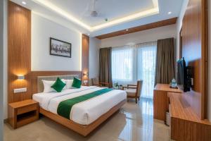 a hotel room with a bed and a television at Hotel Panoramic in Ernakulam