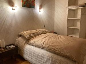 een slaapkamer met een bed en twee lampen aan de muur bij L'Escapade de JOS gite équestre in Pont-de-Salars