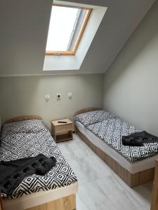 two beds in a room with a window at Wyspówka in Międzyzdroje +49 photos