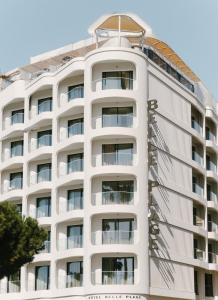 a white apartment building with a white facade at Hôtel & Spa Belle Plage in Cannes