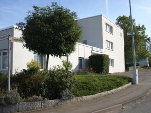 ein weißes Gebäude an der Straßenseite in der Unterkunft Boardingroom in Filderstadt