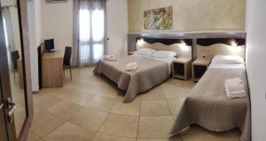 a hotel room with two beds and a television at Bed and breakfast KALE ' in Porto Cesareo