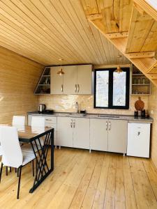 eine Küche mit weißen Schränken und einer Holzdecke in der Unterkunft Emotion Kazbegi in Kazbegi
