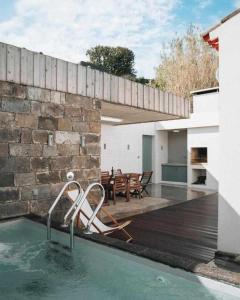 Casa con piscina con mesa y sillas en Casas do Vale A Casa Casa familiar, en Nordeste