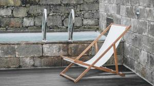 a wooden folding chair sitting on a porch at Casas do Vale A Casa Casa familiar in Nordeste