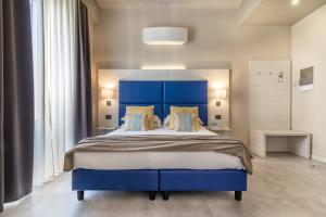 a bedroom with a blue bed with a blue headboard at Cinque Terre Gateway in La Spezia