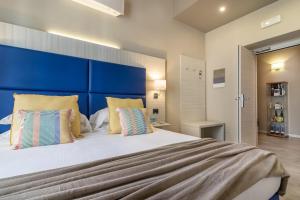 a bedroom with a large bed with a blue headboard at Cinque Terre Gateway in La Spezia