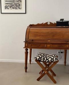 a wooden piano with a pillow on a stool at Casa Tin Tin in Moncarapacho +50 photos
