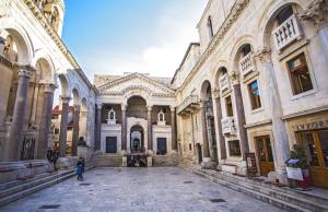 een binnenplaats van een gebouw met een persoon in het midden bij Grisogono Palace Heritage Residence in Split