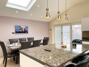 a dining room with a table and chairs at Luxurious Kitchen, 4BR Home with Free Parking near Airport for Contractor Holiday for 8 People in Luton